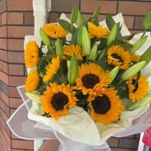 Golden sunflower and lily bouquet wrapped in white paper