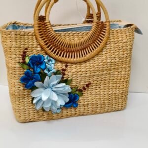 Natural woven handmade eco bag with blue floral decoration and round rattan handles