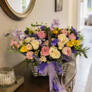 Pastel flower basket with roses, spray roses and soft seasonal flowers