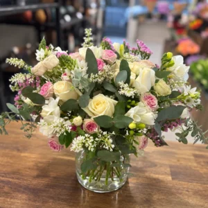 Ivory and blush vase arrangement with cream roses, pink spray roses, white flowers and eucalyptus