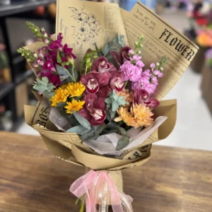 Vintage Charm bouquet with burgundy orchids, pink stock and golden chrysanthemums