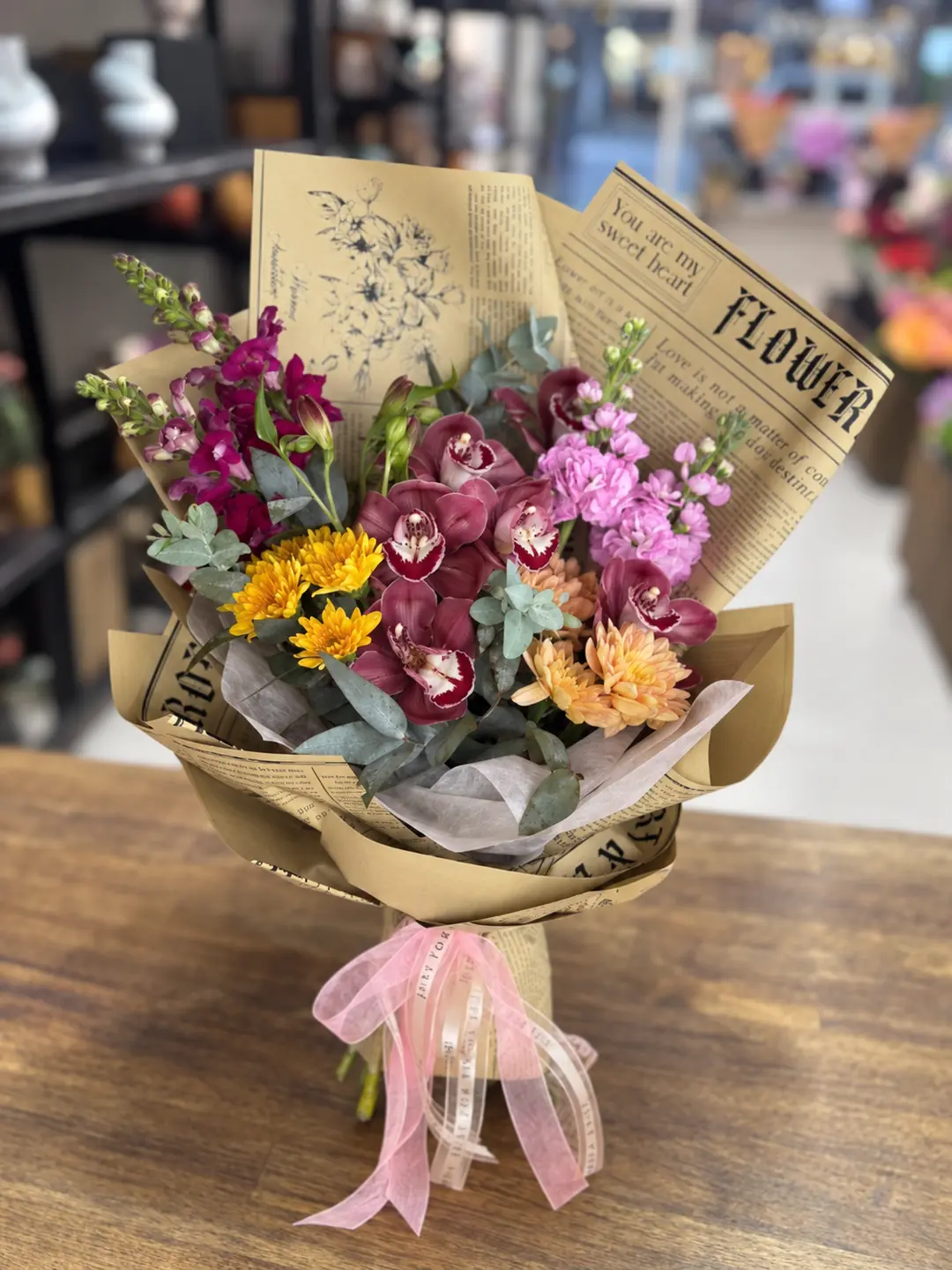 Vintage Charm bouquet with burgundy orchids, pink stock and golden chrysanthemums