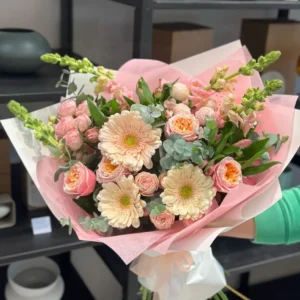 Pastel bouquet of pink roses, peach flowers, cream blooms and eucalyptus