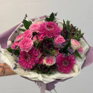 Rounded bouquet of pink roses and purple chrysanthemums