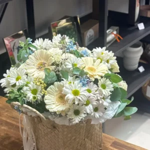 Fresh white and cream flower basket with pale blue accents, eucalyptus and greenery
