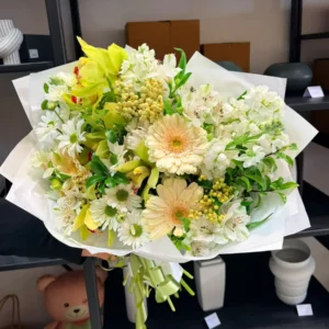 Lemon, cream and white bouquet with cymbidium orchids, gerberas and seasonal flowers.