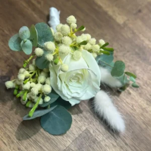 White rose buttonhole with eucalyptus and delicate white flowers.